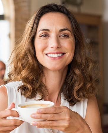 woman holding coffee smiling