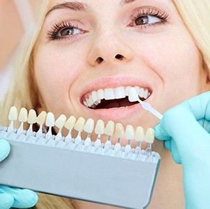 woman comparing tooth to veneer