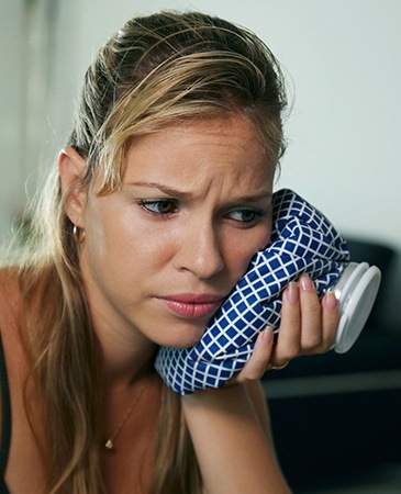 woman with icepack on cheek