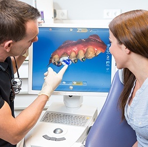 dentist pointing to cerec machine
