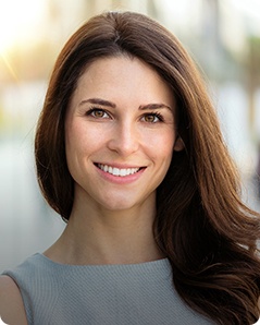 Woman in gray blouse smiling outdoors