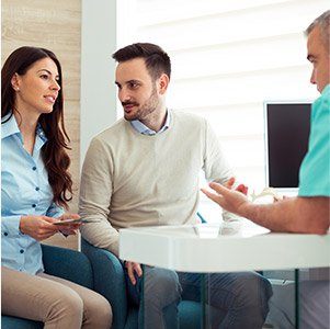 man and wife talking to dentist