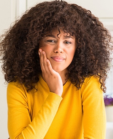 woman in bright yellow shirt in pain