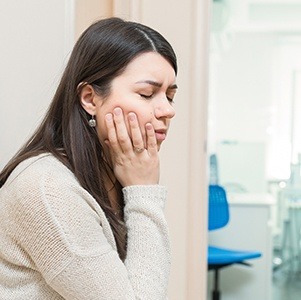 woman holding right cheek