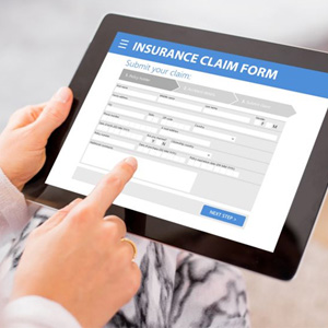 Person filling out insurance claim form on tablet