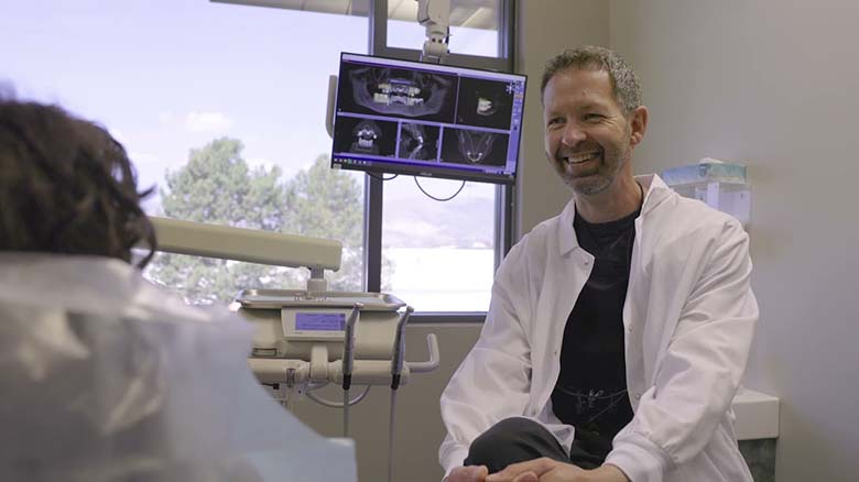 Colorado Springs dentist smiling at patient in treatment chair