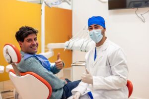 Dentist and patient making thumbs up gesture 