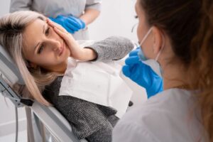 Dental patient with toothache looking at her dentist