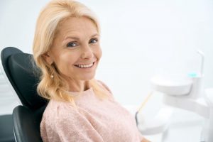 Dental patient smiling after receiving new crown