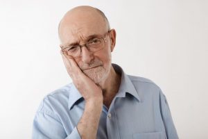 Frowning senior man with oral pain