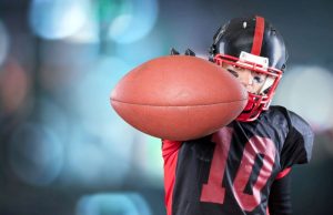 High school football player holding football