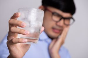 Man experiencing tooth pain after chewing on ice