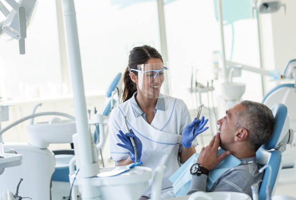 Female dentist smiling while talking to patient about oral cancer