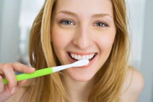 woman brushing teeth to maintain good dental health for life