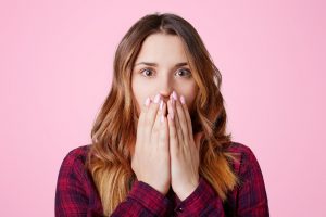 Woman covering mouth to hide her gray teeth