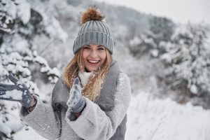 Woman in snow, not bothered by winter mouth issues