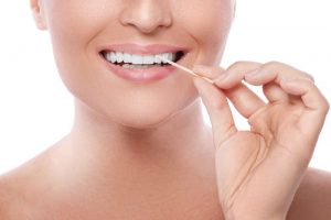 Woman placing toothpick between her teeth