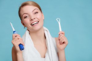 holding toothbrush and tongue scraper
