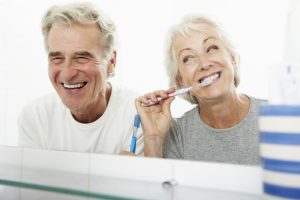 senior couple brushing teeth