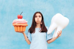 woman holding giant cupcake and tooth