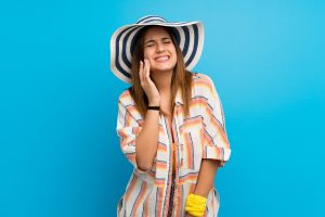 woman in vacation clothes with toothache