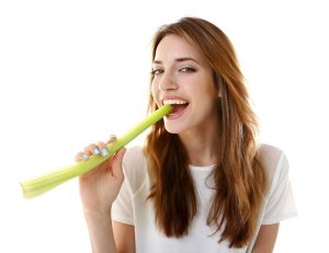 young woman eating celery